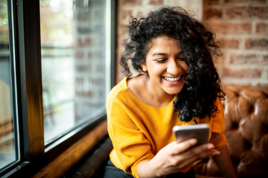 Young woman reading about period symptoms on her phone