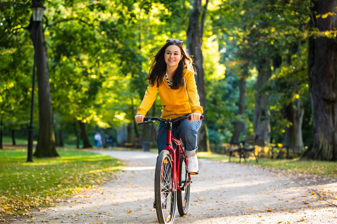 Young woman cycling through a park